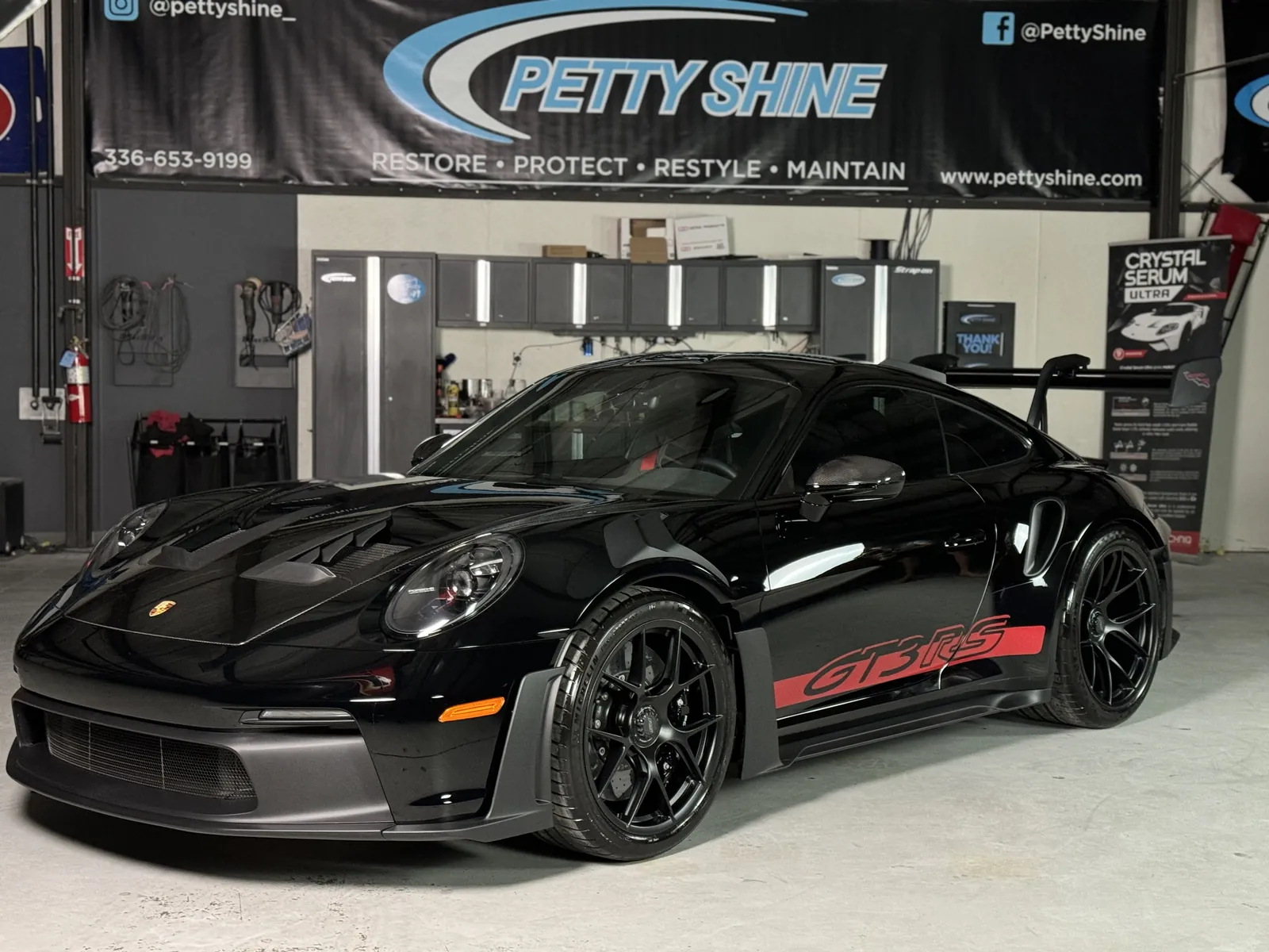 Black Porsche 911 GT3 RS under the Petty Shine banner in the Randleman shop